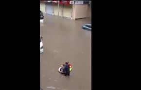بالفيديو... مصري يتحدى الشوارع الغارقة بـ