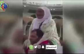 بالفيديو.... شاب يتطوع بحمل مُسنة على كتفيه ويطوف بها حول الكعبة