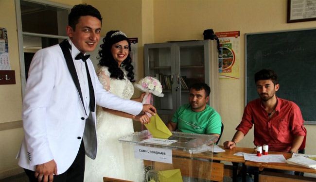 بالصورة: عروسان في تركيا يدليان بصوتيهما في انتخابات الرئاسة