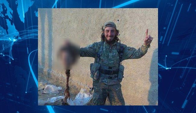 صورة لداعشي يفتخر بقطع رأس إمراة 