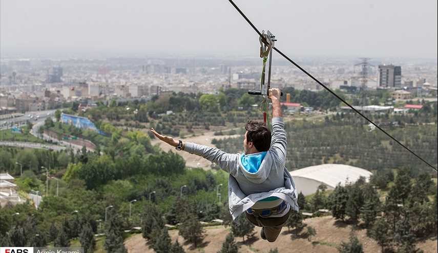 بالصور.. رياضة الانزلاق على الحبل وجسر مشاة معلق في برج ميلاد بطهران