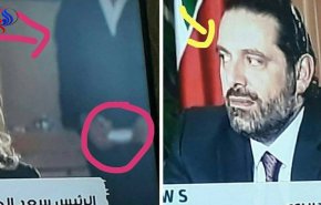نظر إليه بشيء من الريبة.. شاهد رجل ظهر بورقة خلف المذيعة أثناء مقابلة الحريري
