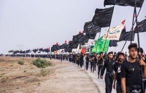 شاهد/منطقة بالعراق تشهد رفع أكبر راية عزاء حسيني على طريق مشاة الأربعين
