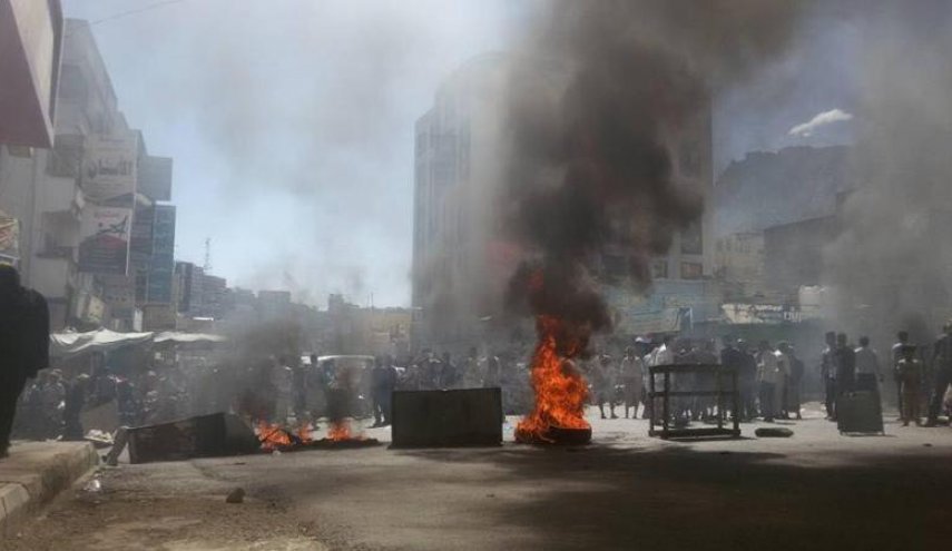 محتجون يمنيون يمزقون صورا لهادي والملك سلمان في تعز