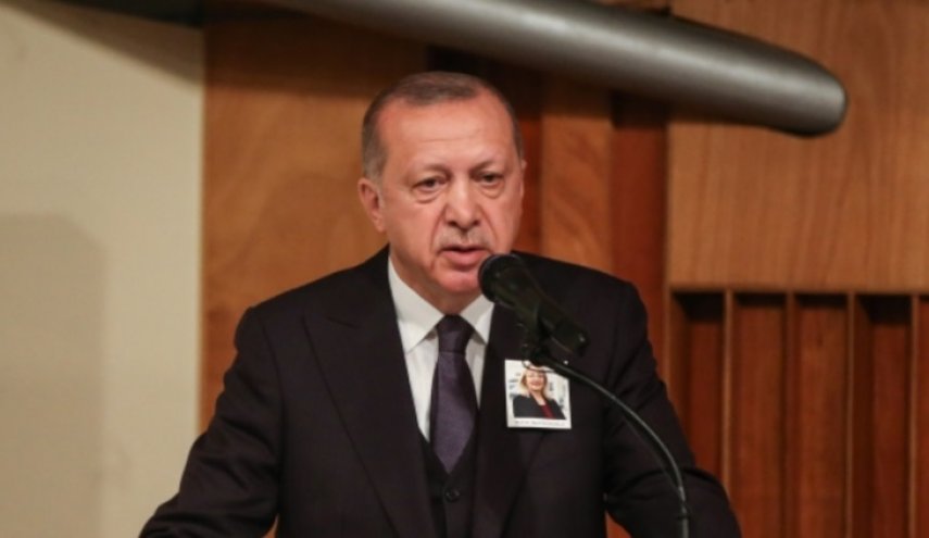 أردوغان يعلق على صدره صورة مسؤولة في الرئاسة التركية