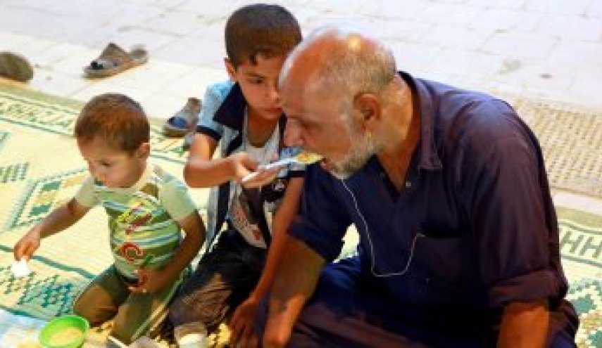 شاهد.. طفل عراقى يطعم والده المبتورة يداه فى إفطار رمضان
