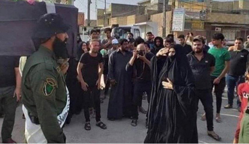 بالصورة.. أم شهيد عراقي تستقبل جنازة إبنها بالتحية العسكرية