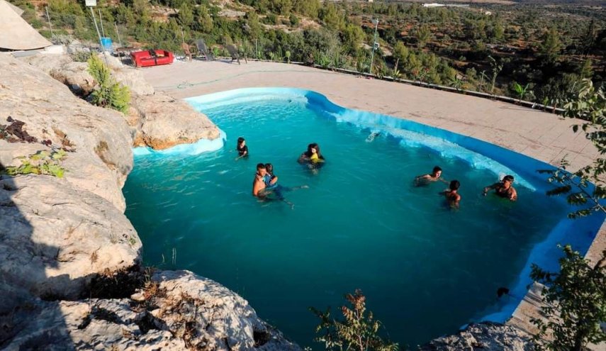 هربا من الحر.. عائلة فلسطينية تحول كهف صخري إلى بركة سباحة