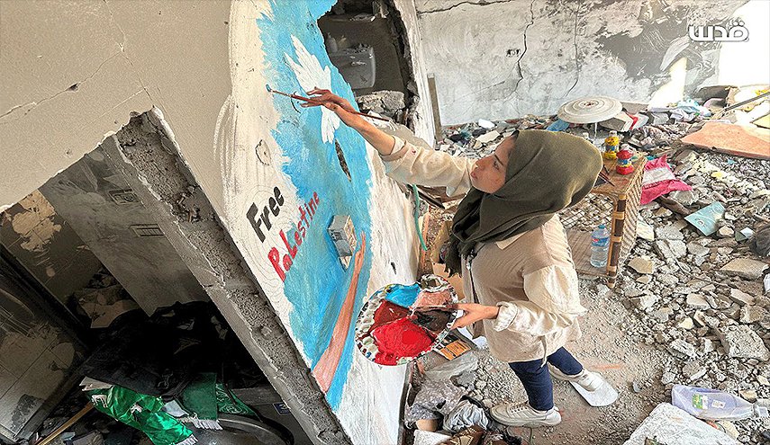 فلسطينية تجسد معاناة شعبها برسم لوحات على ركام المنازل المدمرة