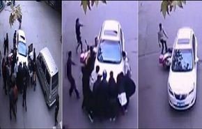 مشهد إنساني لاشخاص يرفعون سيارة من فوق امرأة