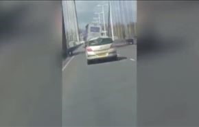 شاهد.. انقلاب شاحنة على جسر مرتفع بفعل الرياح