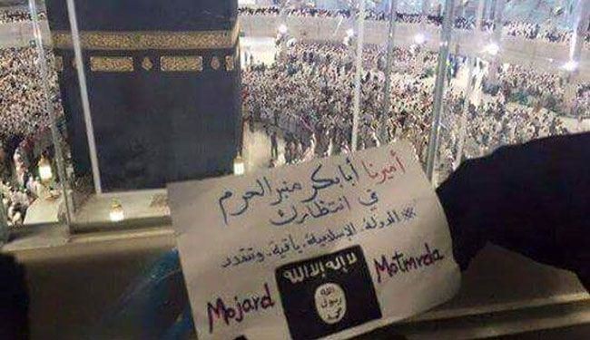 بالصورة، داعشي يتطاول على الحرم المكي ويرفع لوحة مكتوب فيها..
