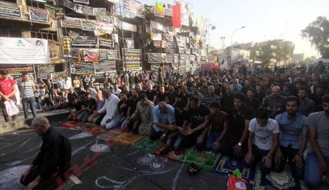 بالصور.. صلاة ودموع وشموع في موقع تفجير الكرادة