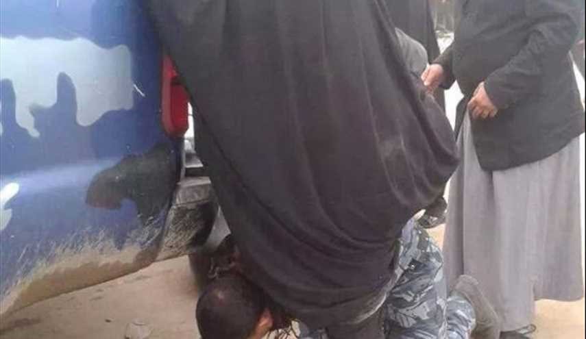 احد مجاهدي الحشد الشعبي ينحني على ركبتيه ليمكن سيدة هربت من بطش داعش ركوب السيارة