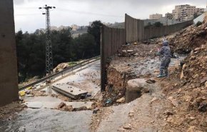بالصور.. ناشطون يسخرون من تدمیر الجدار العنصري بالضفة جراء الامطار 