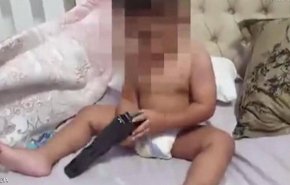 بالفيديو... رضيع يلهو بمسدس حقيقي محشو بالرصاص