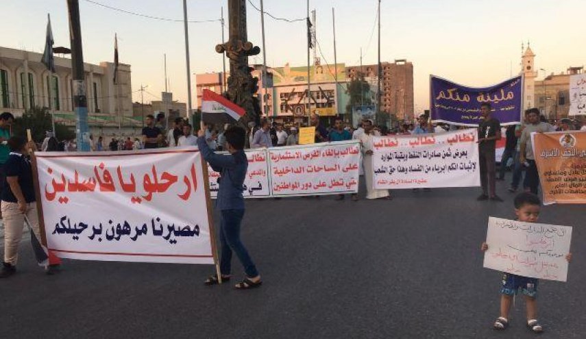 المئات يتظاهرون وسط النجف ويحملون لافتات 