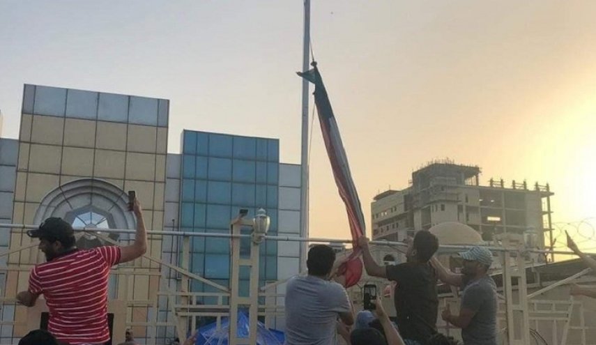 بالصورة.. محتجون ينزلون علم الكويت بسبب ’إساءة نساء البصرة’